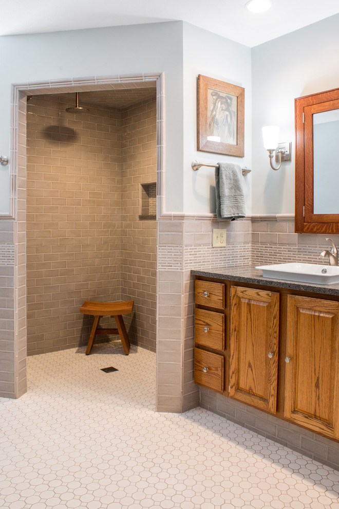 Design ideas for an expansive arts and crafts master bathroom in Milwaukee with raised-panel cabinets, medium wood cabinets, a curbless shower, a one-piece toilet, gray tile, ceramic tile, blue walls, ceramic floors, a vessel sink, quartzite benchtops, white floor, an open shower and grey benchtops.