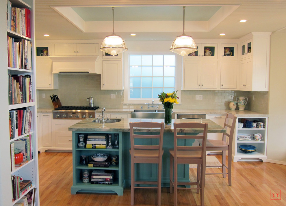 Example of a mid-sized transitional u-shaped light wood floor eat-in kitchen design in Los Angeles with a double-bowl sink, shaker cabinets, quartzite countertops, beige backsplash, ceramic backsplash, stainless steel appliances, white cabinets and an island