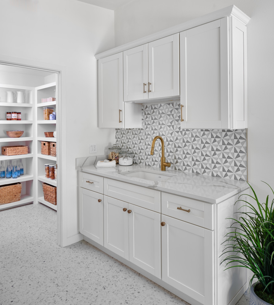 Inspiration for a mid-sized midcentury galley utility room in Austin with an undermount sink, shaker cabinets, white cabinets, quartz benchtops, black splashback, glass tile splashback, white walls, porcelain floors, a side-by-side washer and dryer, white floor, white benchtop and vaulted.