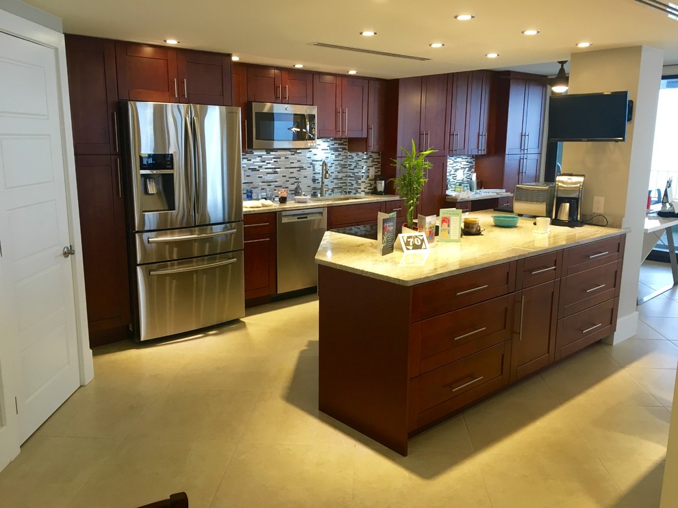 Example of a mid-sized transitional galley beige floor kitchen design in Miami with an undermount sink, shaker cabinets, medium tone wood cabinets, stainless steel appliances, an island, matchstick tile backsplash, limestone countertops and gray backsplash
