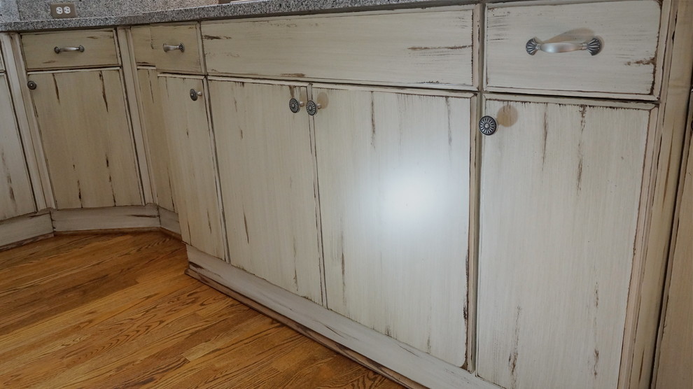 Example of a large mountain style u-shaped medium tone wood floor eat-in kitchen design in Atlanta with an undermount sink, flat-panel cabinets, distressed cabinets, quartz countertops, white backsplash, ceramic backsplash, stainless steel appliances and beige walls