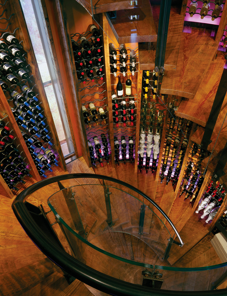 Inspiration for an eclectic wine cellar in Other with medium hardwood floors and storage racks.