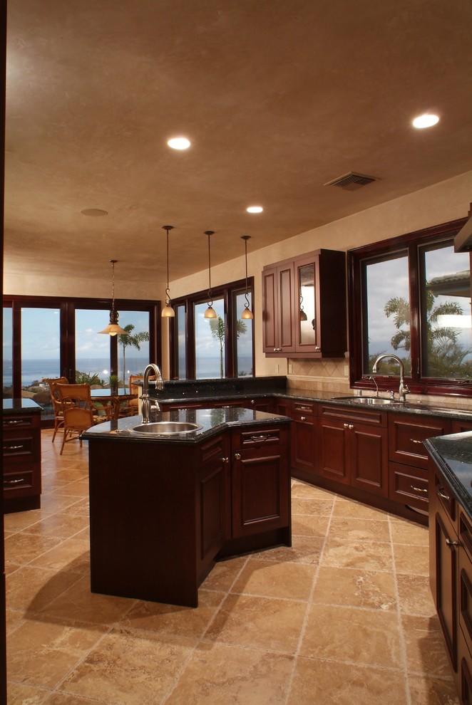 Inspiration for a tropical kitchen in Hawaii with a drop-in sink, recessed-panel cabinets and dark wood cabinets.