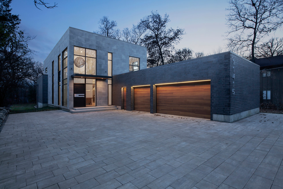 This is an example of a mid-sized modern two-storey concrete grey house exterior in Chicago with a flat roof.