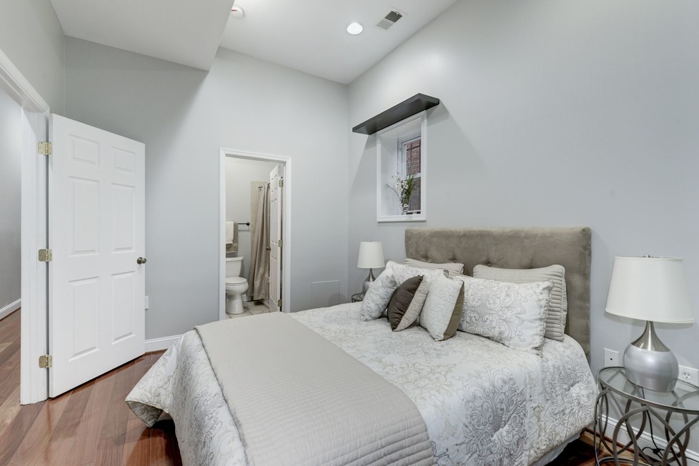 This is an example of a small transitional guest bedroom in DC Metro with grey walls, light hardwood floors, beige floor and no fireplace.