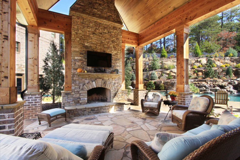 Design ideas for a traditional patio in Atlanta with a fire feature, natural stone pavers and a roof extension.