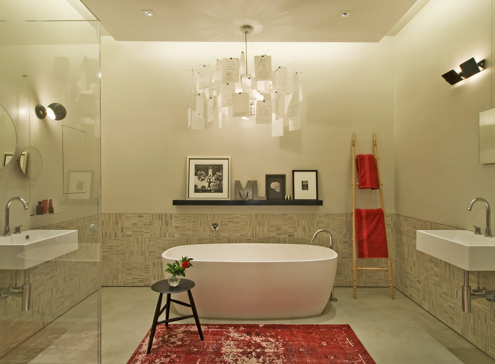 Photo of an industrial bathroom in New York with a freestanding tub.