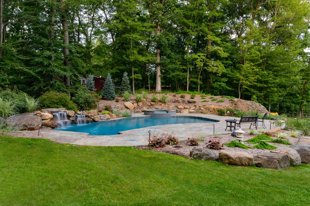 Country backyard kidney-shaped pool in New York with a hot tub.