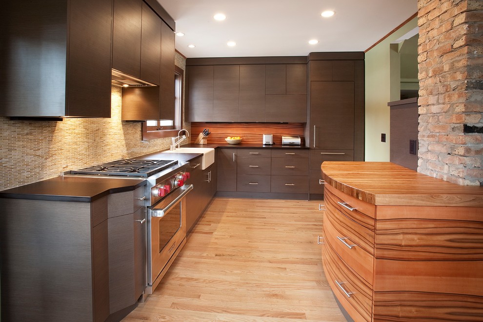 This is an example of a contemporary u-shaped separate kitchen in Other with a farmhouse sink, flat-panel cabinets, dark wood cabinets, beige splashback, glass tile splashback and panelled appliances.
