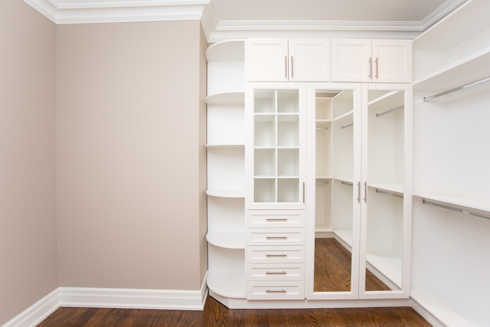 This is an example of a large traditional gender-neutral dressing room in Toronto with white cabinets, dark hardwood floors and recessed-panel cabinets.