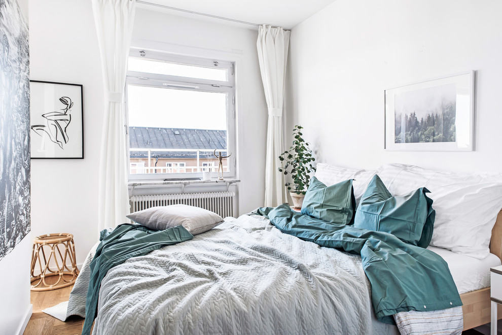 This is an example of a small scandinavian master bedroom in Stockholm with white walls.