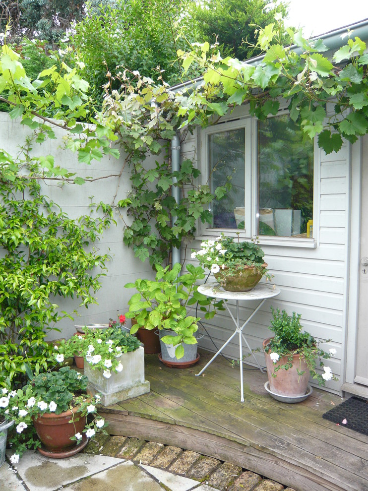Inspiration for a small traditional backyard formal garden in London with a container garden and decking.
