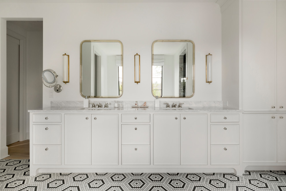 This is an example of a classic ensuite bathroom in Minneapolis with white cabinets, a freestanding bath, an alcove shower, white tiles, white walls, marble flooring, a built-in sink, marble worktops, grey floors, a hinged door, grey worktops, an enclosed toilet, double sinks, a built in vanity unit and flat-panel cabinets.