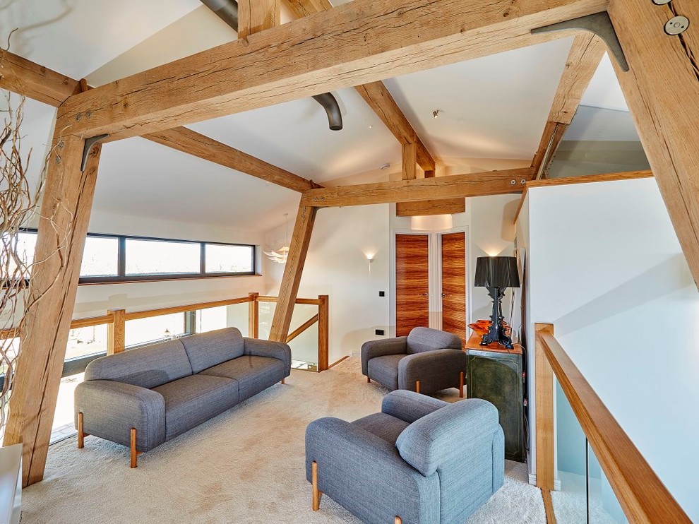 This is an example of a mid-sized contemporary loft-style family room in Devon with white walls and carpet.