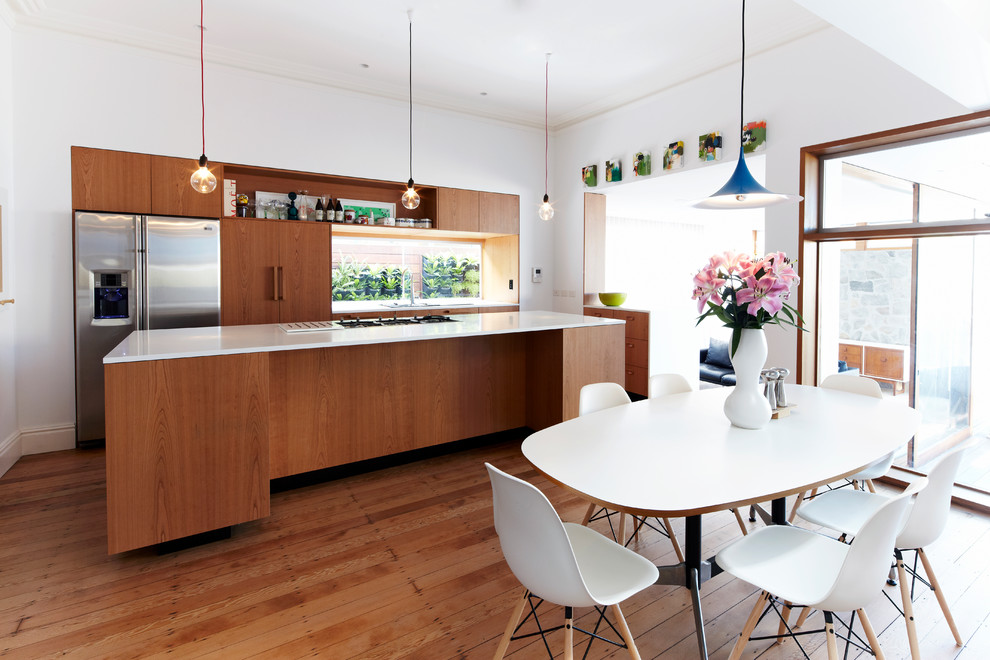 Mid-sized contemporary l-shaped eat-in kitchen in Sydney with flat-panel cabinets, medium wood cabinets, stainless steel appliances, medium hardwood floors, with island, an undermount sink and glass sheet splashback.