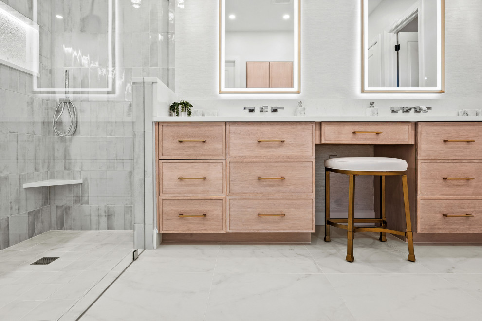 Example of a transitional master gray tile and porcelain tile porcelain tile, white floor and double-sink walk-in shower design with shaker cabinets, light wood cabinets, a two-piece toilet, white walls, an undermount sink, quartz countertops, white countertops, a niche and a built-in vanity