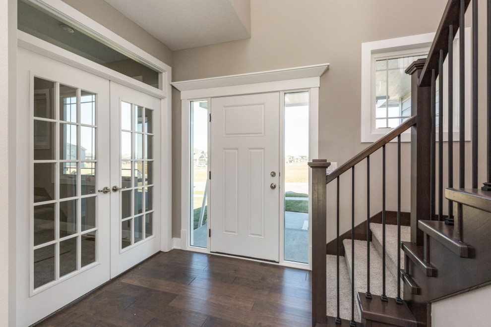 Inspiration for a mid-sized transitional medium tone wood floor and brown floor foyer remodel with beige walls and a white front door