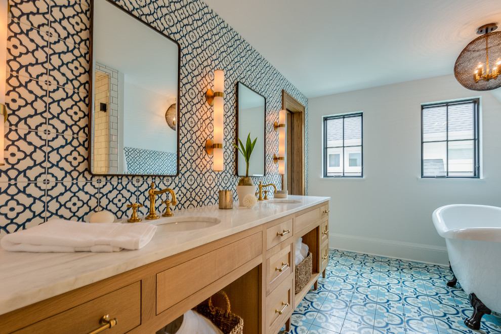 Inspiration for a transitional bathroom in Minneapolis with flat-panel cabinets, medium wood cabinets, a claw-foot tub, multi-coloured tile, white walls, an undermount sink, multi-coloured floor and white benchtops.