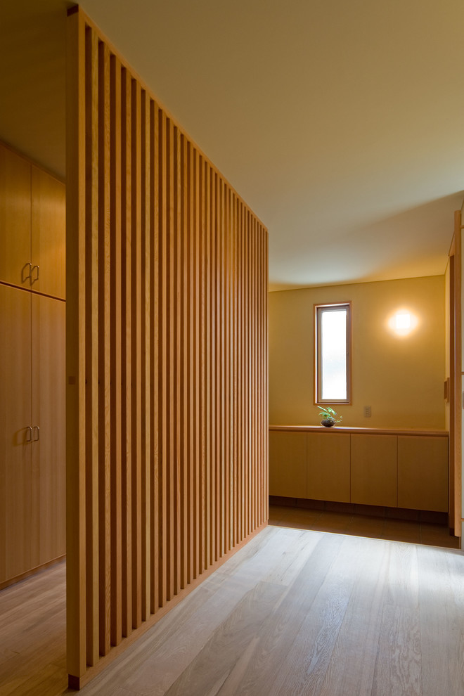Photo of an asian entry hall in Tokyo Suburbs with beige walls, medium hardwood floors and beige floor.