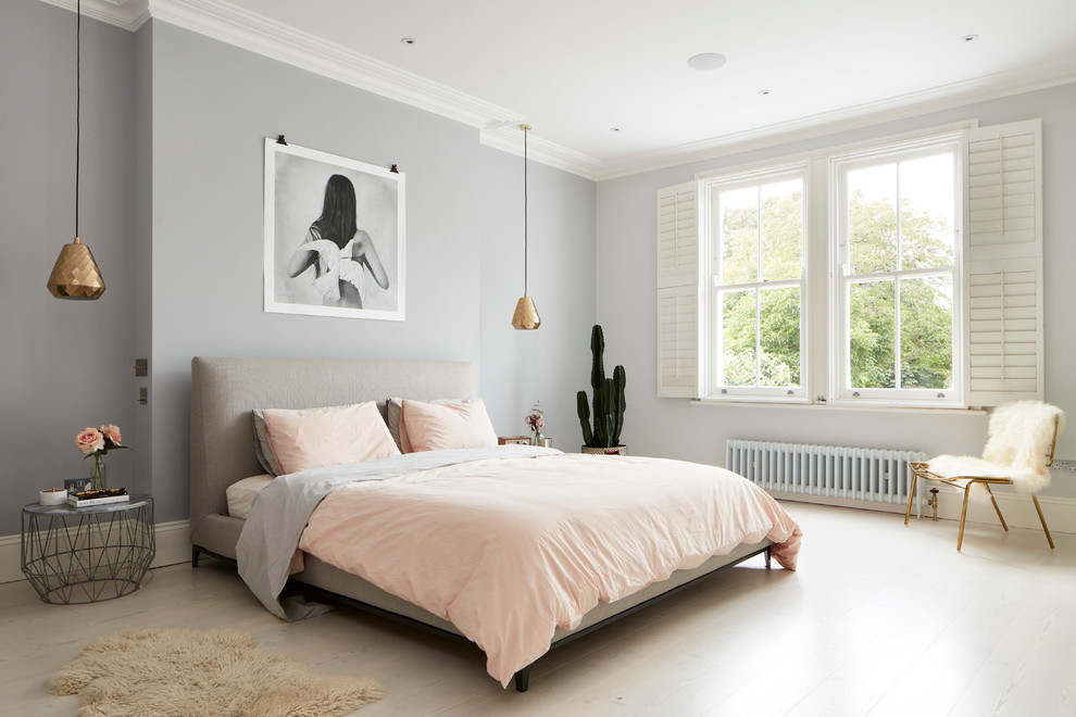 Inspiration for a large contemporary master bedroom in London with grey walls and light hardwood floors.