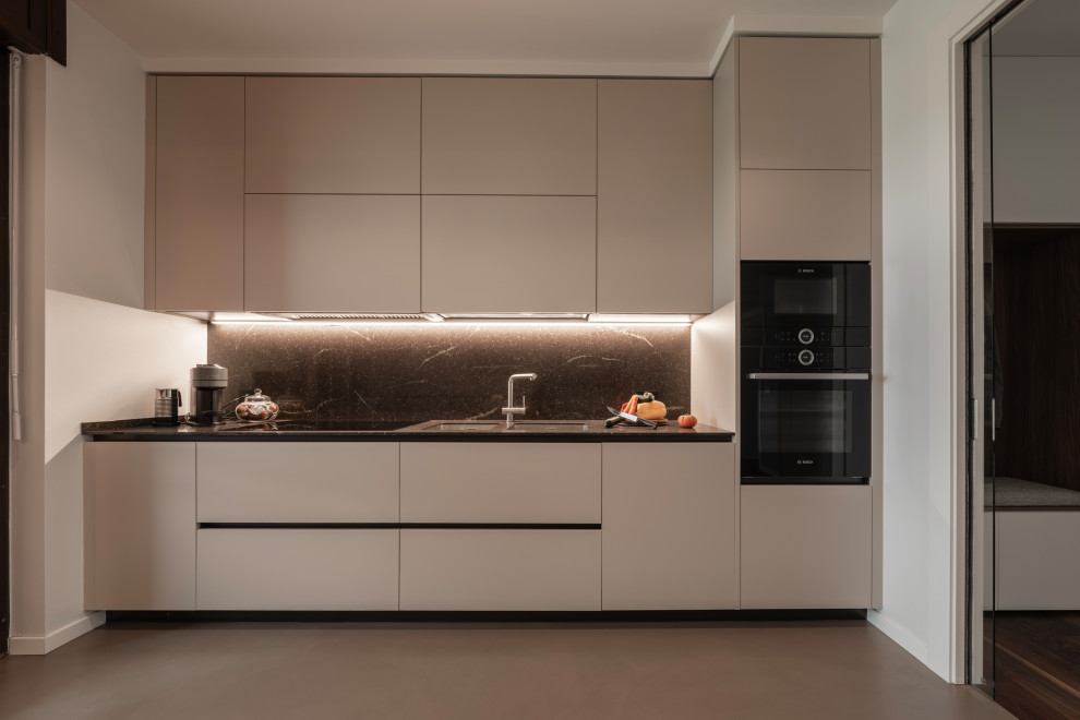 Design ideas for a large modern galley enclosed kitchen in Milan with a double-bowl sink, flat-panel cabinets, beige cabinets, composite countertops, brown splashback, porcelain splashback, black appliances, dark hardwood flooring, no island, brown floors, brown worktops and a drop ceiling.