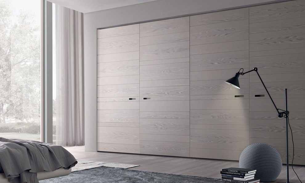 Inspiration for a large contemporary gender-neutral built-in wardrobe in Miami with flat-panel cabinets, light wood cabinets, light hardwood floors and beige floor.