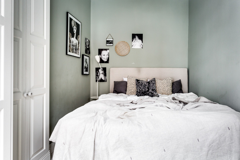 This is an example of a small scandinavian bedroom in Stockholm with green walls.
