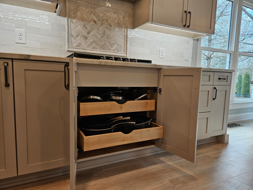 Example of a large transitional l-shaped eat-in kitchen design in Nashville with shaker cabinets, quartz countertops and an island
