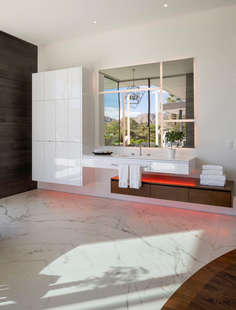 Geräumiges Modernes Badezimmer En Suite mit flächenbündigen Schrankfronten, weißen Schränken, weißer Wandfarbe, Marmorboden, weißem Boden, weißer Waschtischplatte, Einzelwaschbecken, schwebendem Waschtisch und eingelassener Decke in Los Angeles