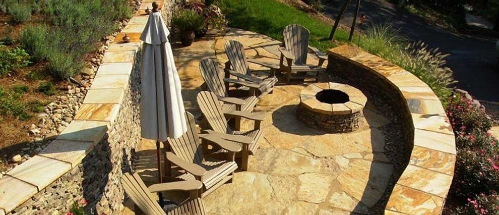 This is an example of a large full sun front yard landscaping with a fire pit.