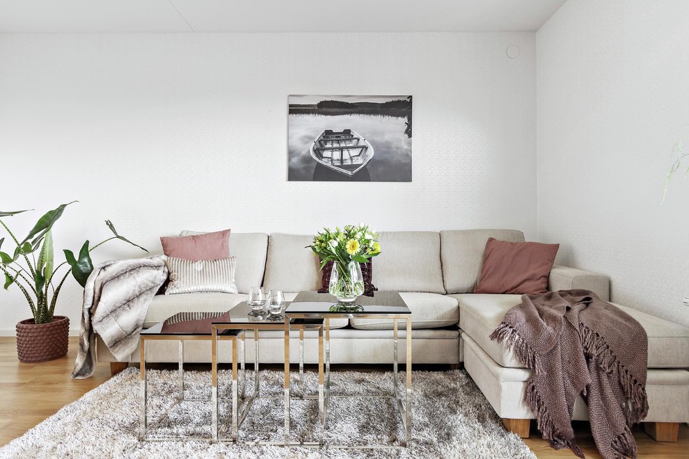 This is an example of a mid-sized scandinavian living room in Stockholm with white walls, medium hardwood floors and brown floor.