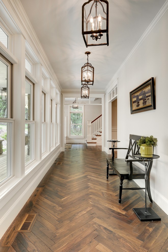 Inspiration for a transitional hallway in Minneapolis with white walls, dark hardwood floors and brown floor.