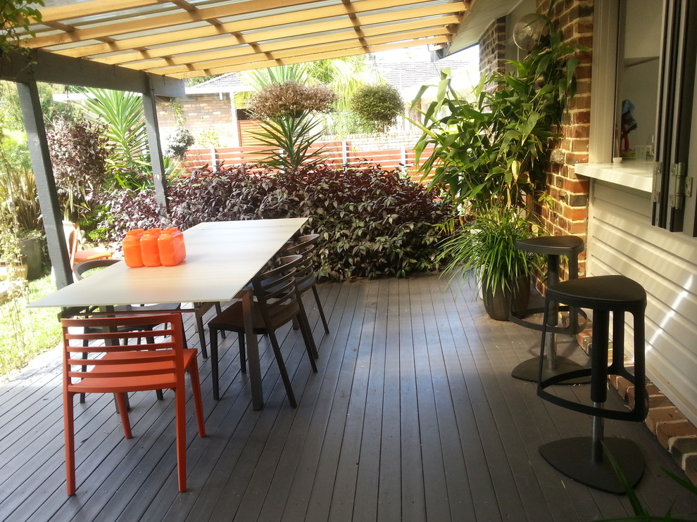 This is an example of a mid-sized contemporary front yard patio in Sydney with decking and an awning.