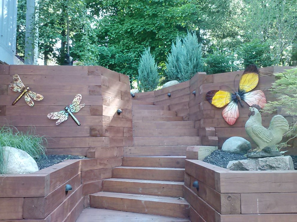 Inspiration for a large country sloped full sun garden for summer in Columbus with a retaining wall and mulch.