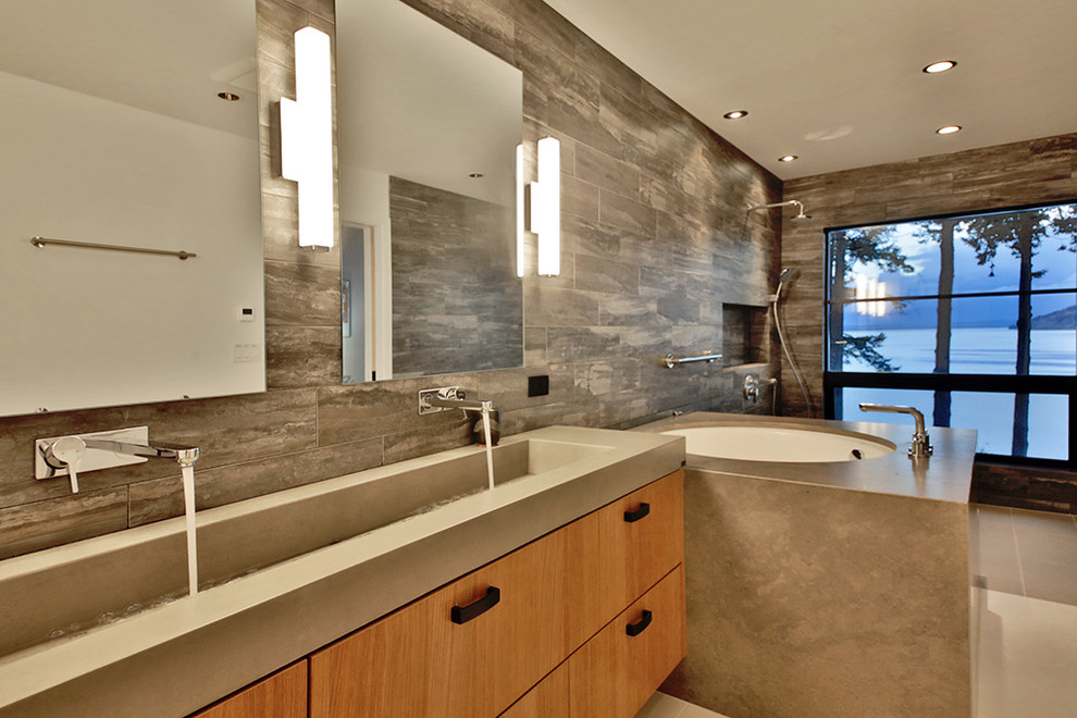 Photo of a large modern master bathroom in Seattle with flat-panel cabinets, light wood cabinets, an undermount tub, an open shower, gray tile, porcelain tile, multi-coloured walls, porcelain floors, a trough sink, engineered quartz benchtops, grey floor, an open shower and grey benchtops.