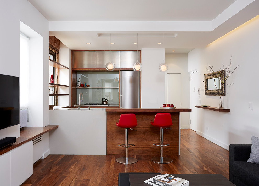Inspiration for a small modern u-shaped open plan kitchen in New York with an undermount sink, stainless steel cabinets, grey splashback, stainless steel appliances, medium hardwood floors and a peninsula.