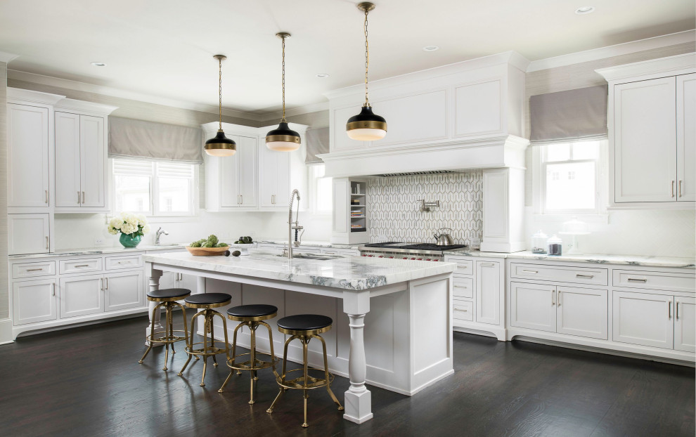 Foto på ett stort vintage vit kök, med en integrerad diskho, skåp i shakerstil, vita skåp, marmorbänkskiva, vitt stänkskydd, stänkskydd i mosaik, rostfria vitvaror, mörkt trägolv, en köksö och brunt golv