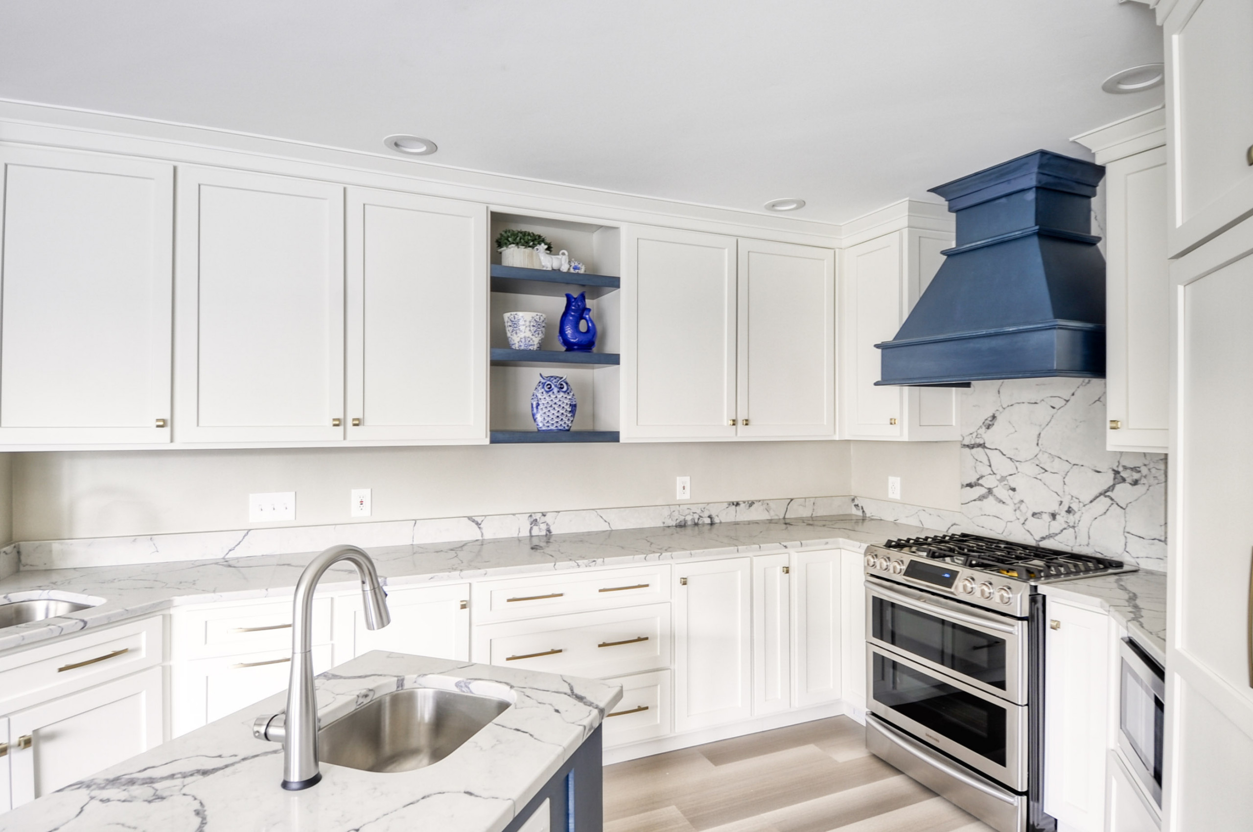 Navy Stained Island, Hood vent and Floating Shelves in White Shaker Kitchen