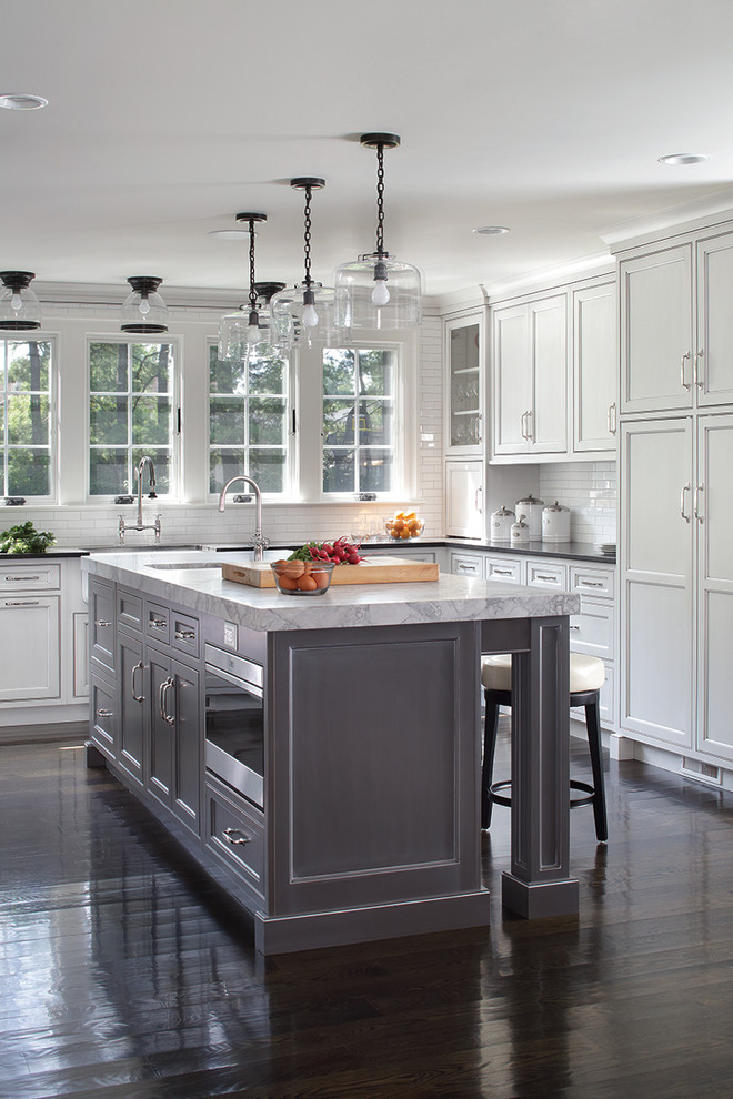Inspiration for a large transitional u-shaped dark wood floor enclosed kitchen remodel with shaker cabinets, white cabinets and an island