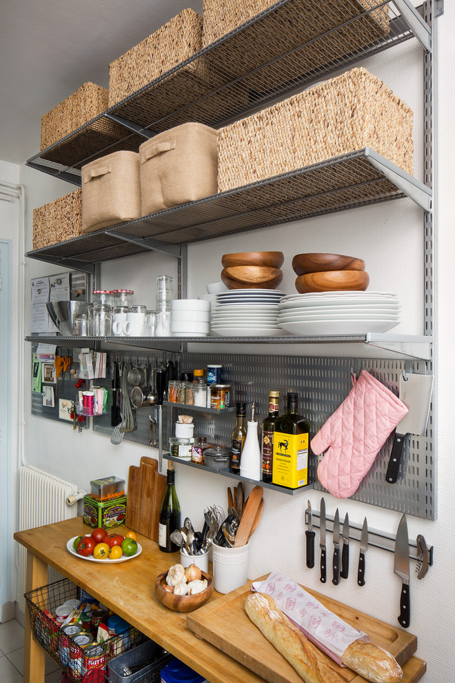 Enclosed kitchen - small contemporary galley ceramic tile enclosed kitchen idea with flat-panel cabinets, white cabinets, stainless steel countertops, white backsplash, ceramic backsplash, white appliances and no island