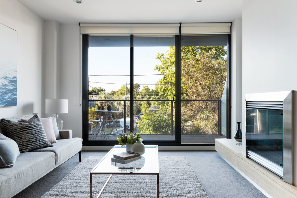 This is an example of a contemporary formal enclosed living room in Melbourne with white walls, carpet, a standard fireplace, no tv and grey floor.
