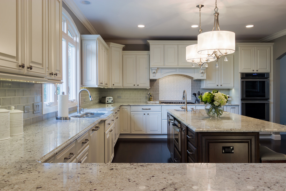 Inspiration for a large transitional u-shaped dark wood floor kitchen remodel in Chicago with a double-bowl sink, raised-panel cabinets, white cabinets, granite countertops, gray backsplash, subway tile backsplash, stainless steel appliances and an island