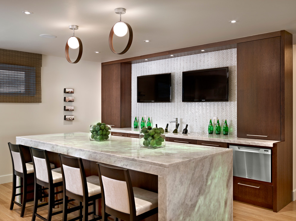 Inspiration for a mid-sized contemporary galley seated home bar in Edmonton with light hardwood floors, flat-panel cabinets, dark wood cabinets and white splashback.