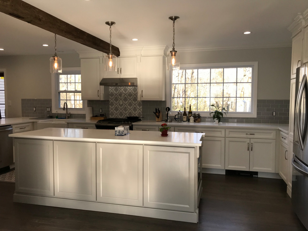 Example of a large transitional u-shaped ceramic tile and gray floor eat-in kitchen design with a farmhouse sink, recessed-panel cabinets, white cabinets, quartz countertops, gray backsplash, subway tile backsplash, stainless steel appliances, an island and white countertops