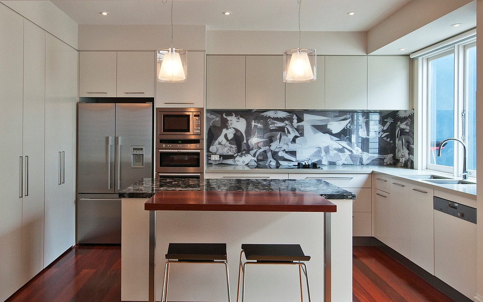 Photo of a large contemporary l-shaped open plan kitchen in Melbourne with flat-panel cabinets, black splashback, glass sheet splashback, stainless steel appliances, an undermount sink, beige cabinets, quartz benchtops, with island and dark hardwood floors.