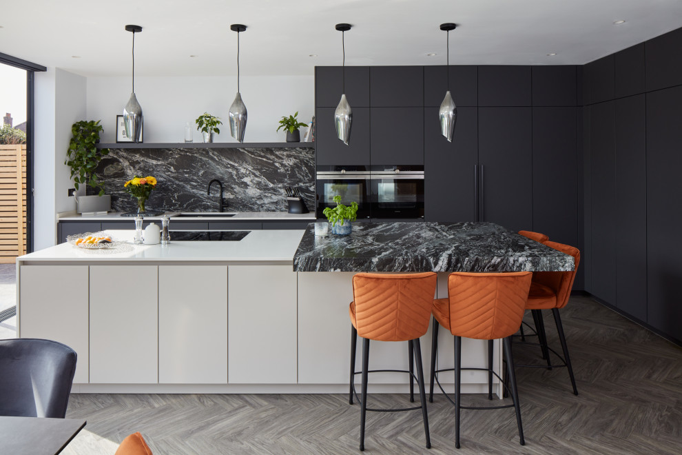 Inspiration for a large contemporary l-shaped kitchen/diner in London with flat-panel cabinets, black cabinets and an island.