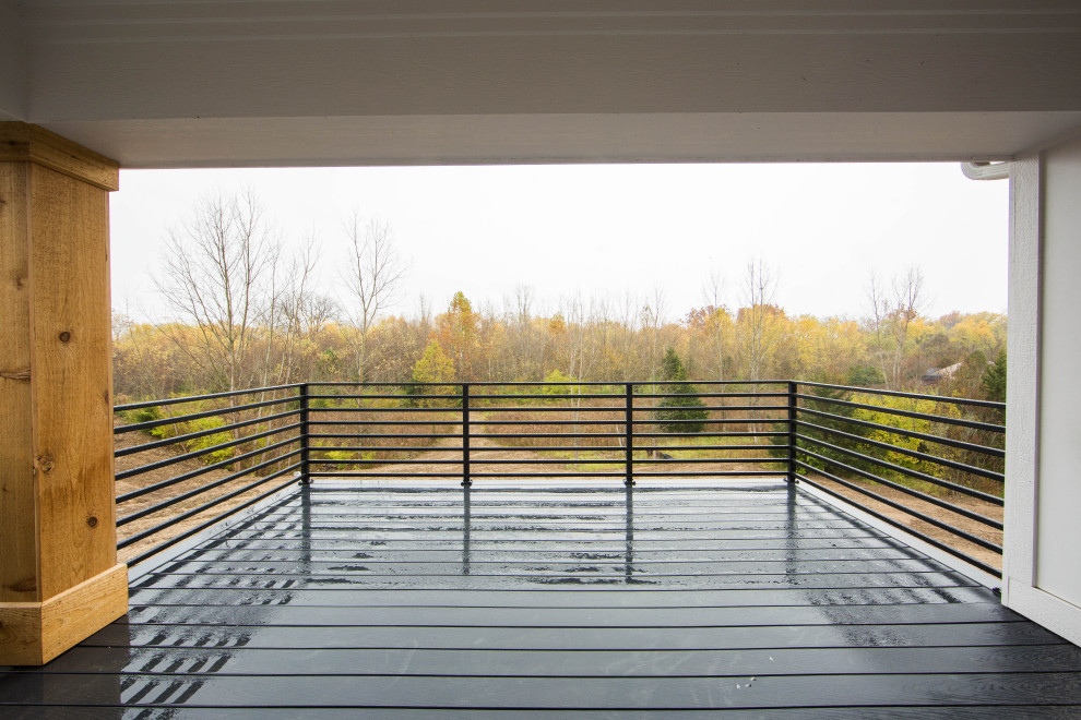 Cette image montre un grand balcon design avec une extension de toiture et un garde-corps en métal.