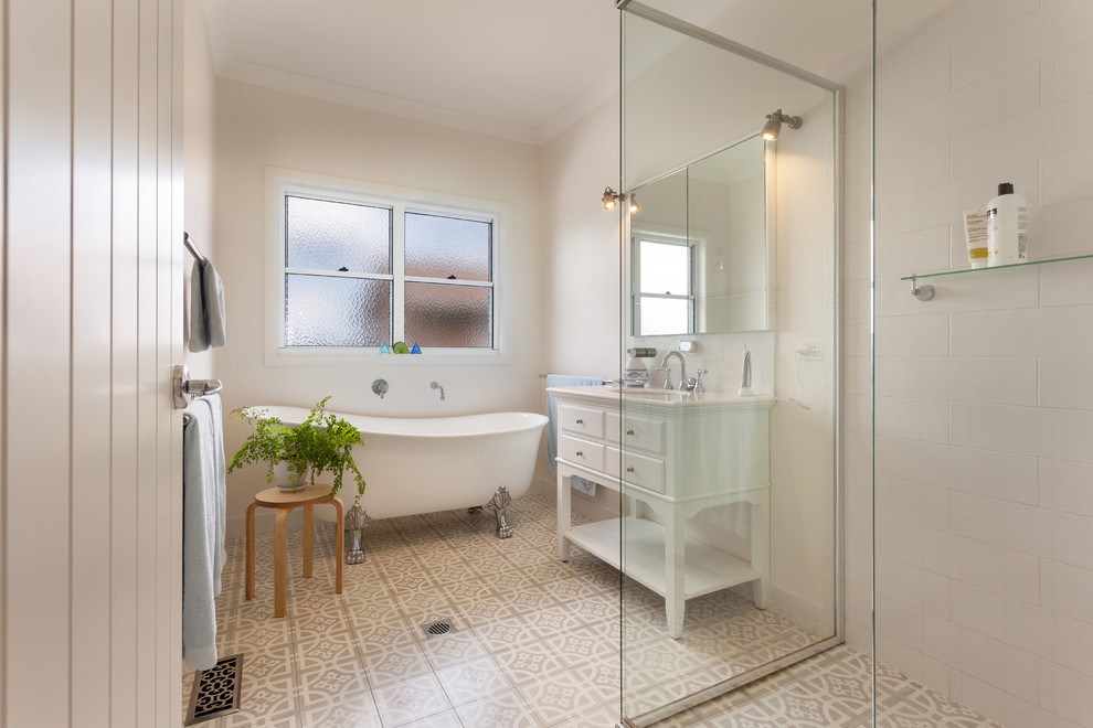 Inspiration for a mid-sized beach style kids bathroom in Other with a claw-foot tub, a corner shower, white tile, ceramic tile, white walls, cement tiles, beige floor and a hinged shower door.