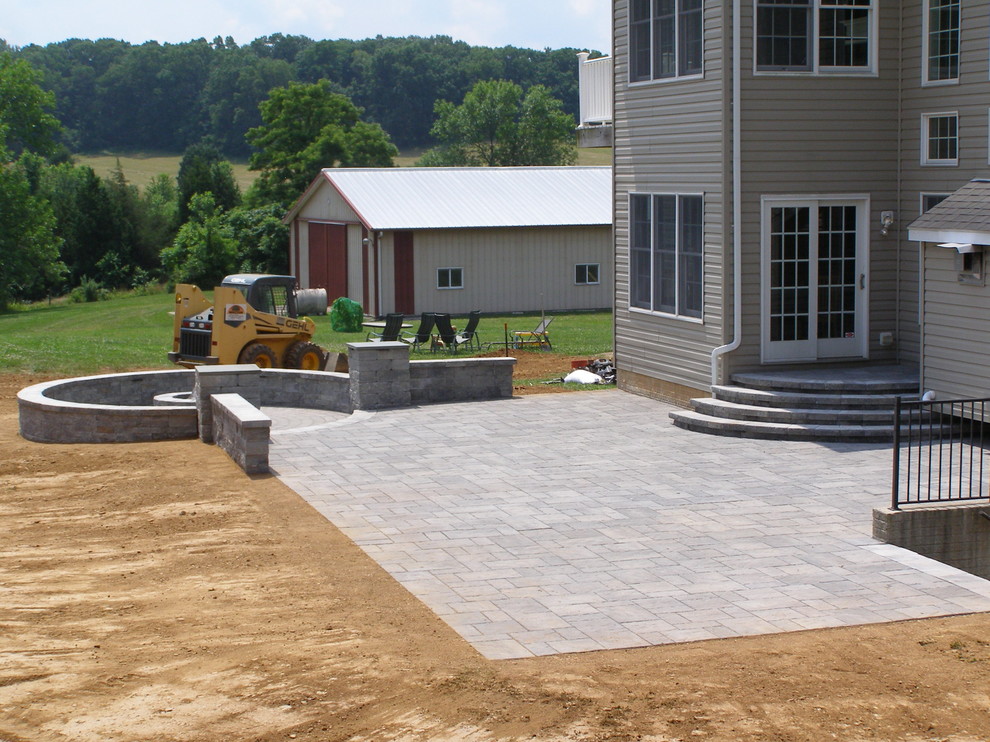 Photo of a mid-sized contemporary backyard patio in Baltimore with a fire feature, natural stone pavers and no cover.