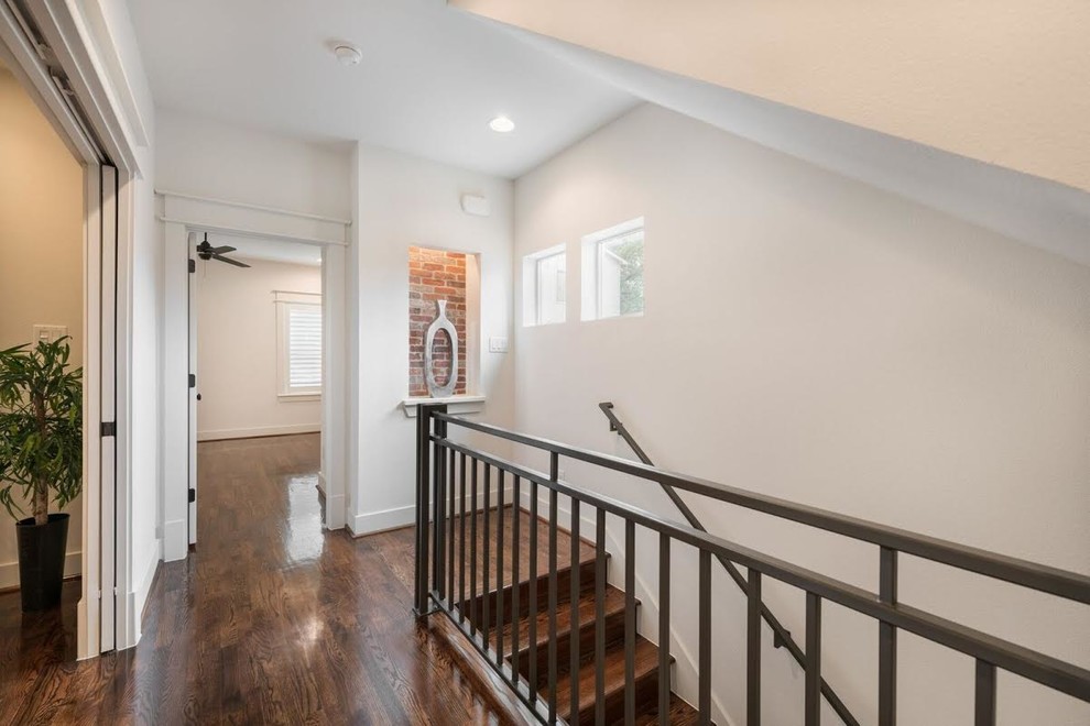 Photo of a mid-sized traditional wood straight staircase in Houston with wood risers and metal railing.